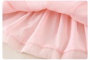Detailed close-up of pink layered organza fabric with fine pleats on the girls' summer dress