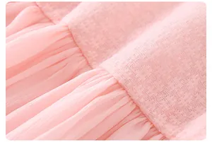Macro detail of pink pleated chiffon fabric and square textured lace on a girl's summer dress