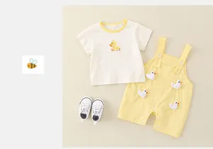 Dettaglio dell'outfit estivo neonato con maglietta a papera e salopette gialla corta