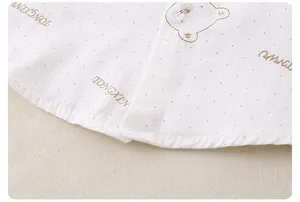 Close-up of baby shirt fabric with cartoon bear prints and white button detail
