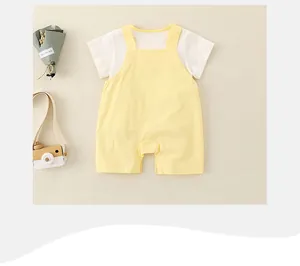 Détail ensemble coton bébé avec t-shirt blanc et salopette canard jaune