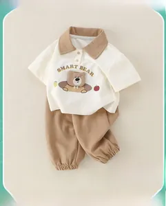 Détail d'un ensemble polo et pantalon en coton pour bébé garçon avec motif ours