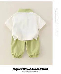 Détail d'un ensemble polo en coton pour bébé avec chemise blanche et short vert