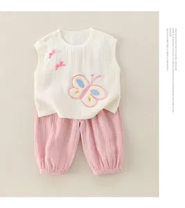 Détail d'un ensemble bébé en gaze de coton avec broderie papillon et texture gaufrée