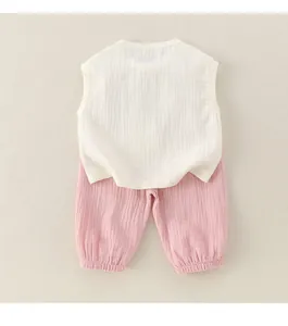 Vue à plat d'un ensemble d'été en gaze de coton pour bébé avec tissu respirant et pantalon rose