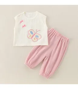 Détail d'un ensemble bébé en gaze de coton avec broderie papillon rose et petits nœuds