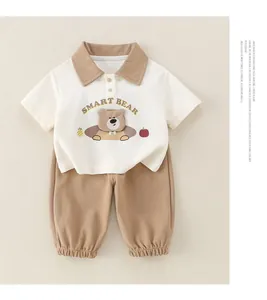 Détail de l'ensemble polo bébé garçon en coton avec broderie ours et pantalon marron