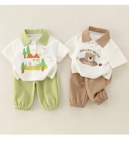 Détail de l'ensemble polo et short en coton pour bébé garçon avec motifs ours et maison