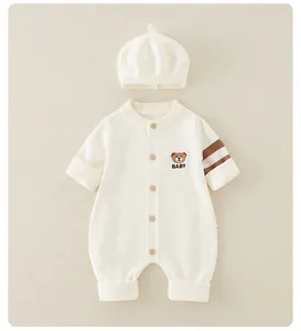 Detail of baby knitted romper with bear embroidery, matching hat and brown striped sleeves