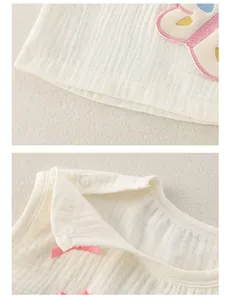 Détail du tissu en mousseline de coton doux avec broderies papillons colorées et pressions