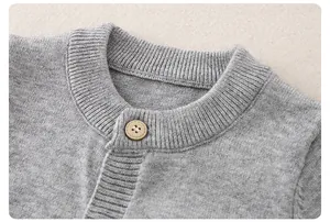 Close-up of light gray knit baby romper showing ribbed neckline and fine texture