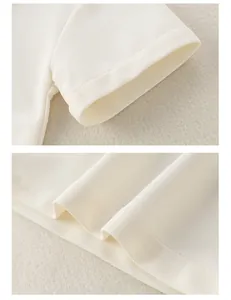 Détail du polo en coton blanc montrant le tissu en maille et les coutures de manche