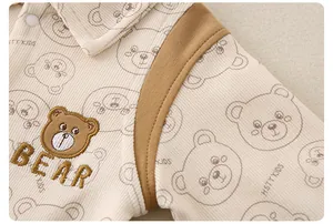 Close-up of baby corduroy romper featuring bear embroidery and cute striped texture