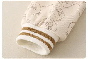 Detail view of baby romper ribbed cuffs with bear pattern and HSTY KIDS textile