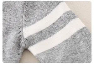 Close-up of baby knit romper showing gray fabric texture and white stripe sleeve detail