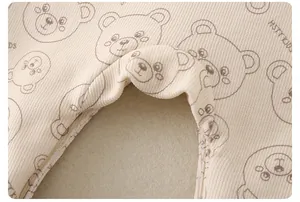 Macro detail of breathable ribbed cotton fabric with cartoon bear print on beige romper