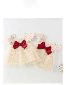 Détail de l'ensemble robe bébé avec jupe en tulle multicouche et grand nœud rouge satiné