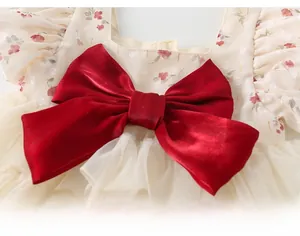 Gros plan d'un nœud en velours rouge et tissu mousseline floral sur un barboteuse