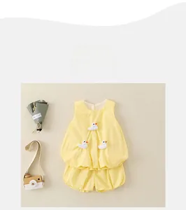 Flat lay of yellow cotton toddler summer set with 3D duck applique and lantern shorts