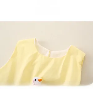 Close-up of baby girl yellow cotton outfit featuring a plush duck and round neckline