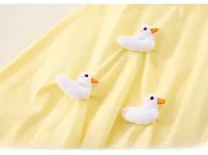 Detail of yellow fabric featuring three cute 3D plush white ducks with orange beaks