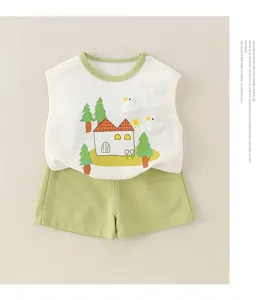 Detail of baby cotton tank top with duck applique and shorts on a sand background