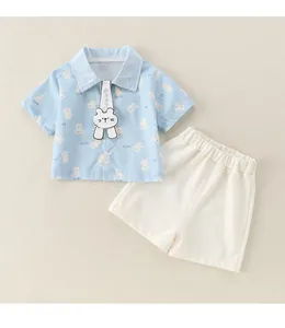 Detail of baby boy cotton summer set featuring blue bear print shirt and white shorts