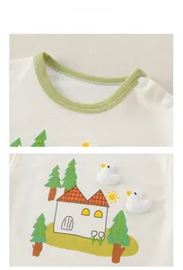 Close-up of cotton baby shirt featuring green ribbed neckline and cartoon duck embroidery