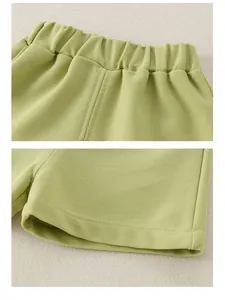 Close-up of light green waffle knit cotton shorts with elastic waistband and rolled hem