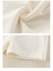 Macro detail of white cotton waffle texture and fine stitching on baby boy clothing