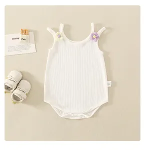 Détail d'un body bébé en coton côtelé blanc avec fleurs 3D et boutons-pression