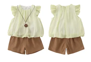 Detailed close-up of light green ruffle top and brown shorts set for baby girls