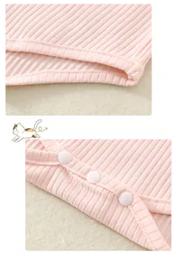 Détail d'un body bébé en coton côtelé rose avec coutures premium et boutons-pression en résine