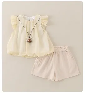 Close-up of ruffled neckline and cute cartoon bear necklace on yellow baby girl top