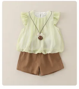 Detail of baby summer set with light green ruffled top and brown cotton shorts