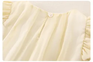Close-up of baby girl top with round neck, back button closure, and vertical texture
