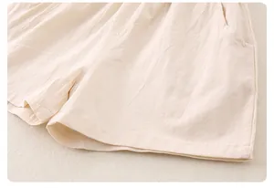 Detailed macro view of beige cotton linen baby shorts with elastic waist and side pockets