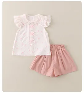Detail der Mädchen Sommerkombi mit Rüschenkragen, rosa Schleifen und passenden Shorts