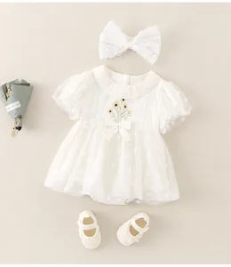 Detail of baby girl bodysuit with daisy embroidery, lace headband and soft baby shoes
