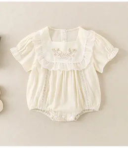 Detailed macro view of the delicate floral embroidery and lace trim on baby cotton romper