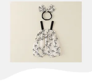 Detail of floral baby bodysuit set with black shoulder straps and matching bow headband