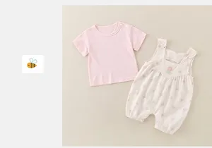 Detail view of cotton baby bodysuit set featuring floral patterns and snap button closures