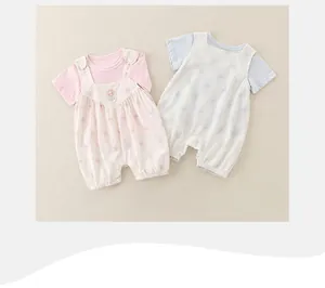 Close-up of floral embroidery on pink cotton baby romper with floral suspender shorts