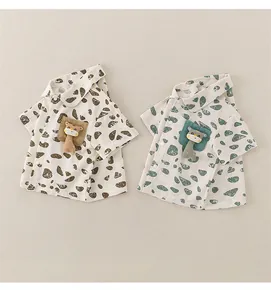 Detail of short-sleeved cotton baby shirts featuring 3D cartoon giraffe on chest pockets