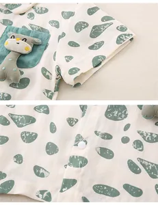 Detail of baby cotton shirt with green pebble print and a 3D plush giraffe pocket