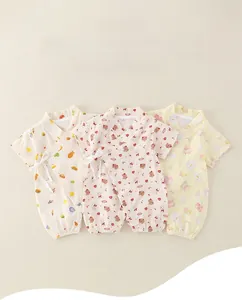 Flat lay of three thin summer cotton baby rompers with soft animal and fruit patterns