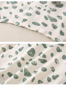 Detail of neckline with button and close-up of green pebble print on cotton fabric