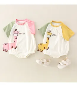 Flat lay of newborn short sleeve cotton rompers with giraffe applique and baby sandals