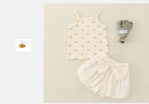 Detail van geribbelde babyhemdje met rode strikjes en bijpassende pofbroek in crème
