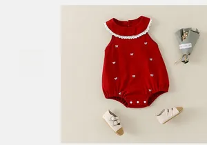 Détail du body rouge pour bébé avec col Claudine en dentelle et broderie nœud